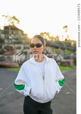 Young Asian Woman in Sporty Casual Outfit Outdoors Wearing Sunglasses 133499573