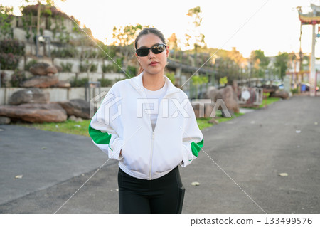 Young Asian Woman in Sporty Casual Outfit Outdoors Wearing Sunglasses 133499576