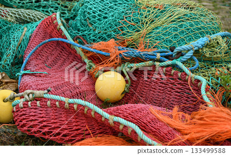 Multicolored green red fishing nets in the port Multicolored green red fishing nets in the port 133499588