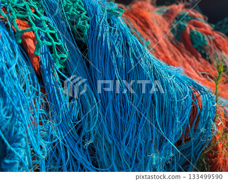 Multicolored orange blue fishing nets in the port Multicolored orange blue fishing nets in the port 133499590