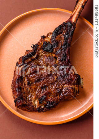 Grilled bone-in meat, beef tomahawk steak, juicy barbecued meat. Tomahawk steak Grilled bone-in meat, beef tomahawk steak, juicy barbecued meat. Tomahawk steak 133499693