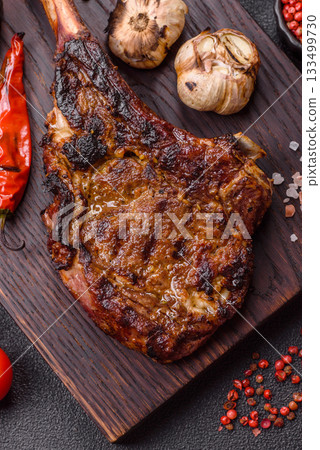 Grilled bone-in meat, beef tomahawk steak, juicy barbecued meat. Tomahawk steak Grilled bone-in meat, beef tomahawk steak, juicy barbecued meat. Tomahawk steak 133499730