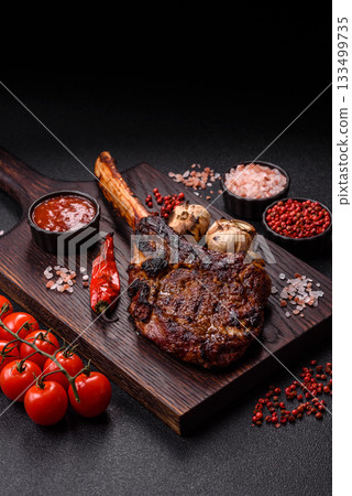 Grilled bone-in meat, beef tomahawk steak, juicy barbecued meat. Tomahawk steak Grilled bone-in meat, beef tomahawk steak, juicy barbecued meat. Tomahawk steak 133499735