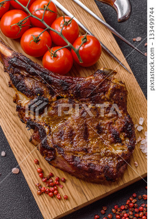 Grilled bone-in meat, beef tomahawk steak, juicy barbecued meat. Tomahawk steak Grilled bone-in meat, beef tomahawk steak, juicy barbecued meat. Tomahawk steak 133499744
