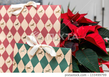 Christmas poinsettia placed with decorative present boxes Christmas poinsettia placed with decorative present boxes 133499799