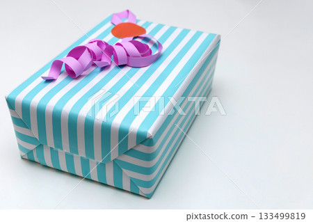 Striped gift box with pink ribbon flat lay Striped gift box with pink ribbon flat lay 133499819