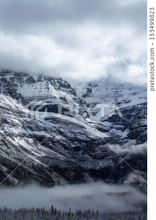 Snowy Rocky Mountains shrouded in mist_Vertical Snowy Rocky Mountains shrouded in mist_Vertical 133499823