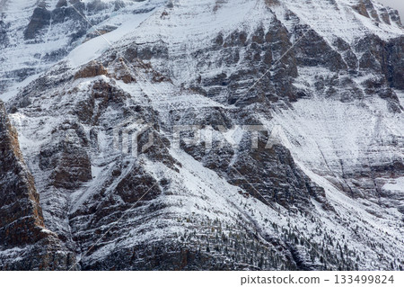 一座白雪皚皚的岩山的崎嶇岩壁 一座白雪皚皚的岩山的崎嶇岩壁 133499824
