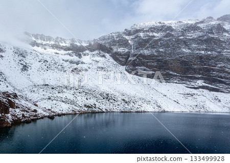Snow-covered rocky mountains and deep blue lake 133499928