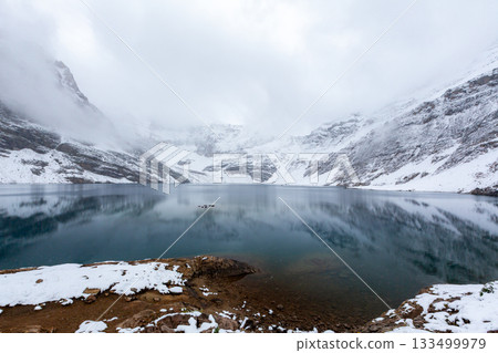 高山湖泊籠罩在薄霧和雪之中 133499979
