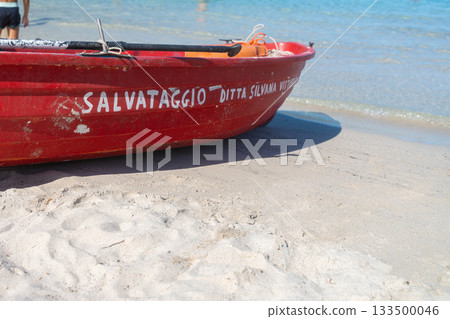 The rescue boat rests near the waters edge, symbolizing lifeguard presence and seaside safety. A strong, recognizable element in beach photography 133500046