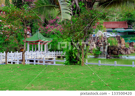 A picturesque traditional-style pavilion stands by the water in the Nanshan Park, Hainan, China A picturesque traditional-style pavilion stands by the water in the Nanshan Park, Hainan, China 133500420