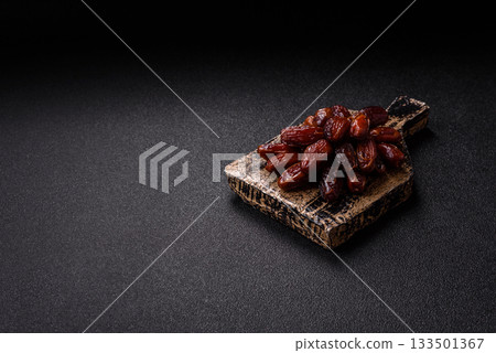Dried dates in a ceramic plate, arabic food for the ramadan table. Dried dates as a background Dried dates in a ceramic plate, arabic food for the ramadan table. Dried dates as a background 133501367