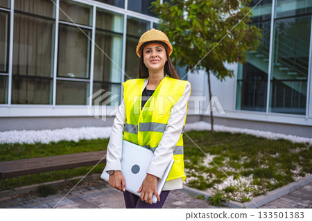 Smiling female safety engineer outdoors Smiling female safety engineer outdoors 133501383