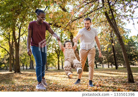 Joyful family moments under golden autumn leaves in the park 133501396