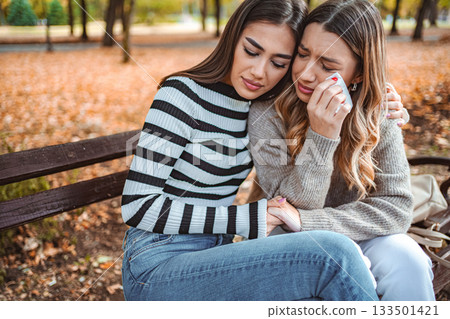 Girls sharing a heartfelt moment of love and support in a cozy autumn park Girls sharing a heartfelt moment of love and support in a cozy autumn park 133501421