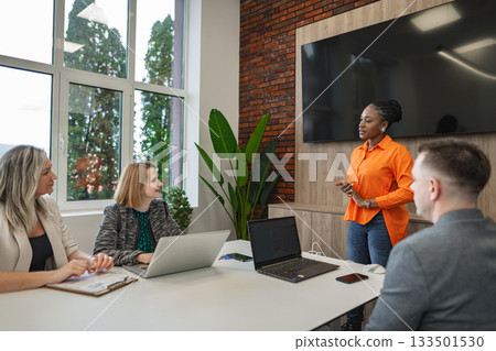 Group of People Sitting Around Table With Laptops 133501530