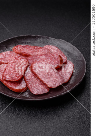 Sliced salami sausage, smoked meat as a delicacy for the table. Salami sausage Sliced salami sausage, smoked meat as a delicacy for the table. Salami sausage 133501690