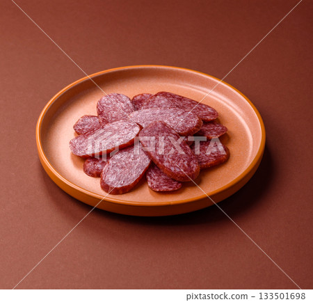 Sliced salami sausage, smoked meat as a delicacy for the table. Salami sausage Sliced salami sausage, smoked meat as a delicacy for the table. Salami sausage 133501698