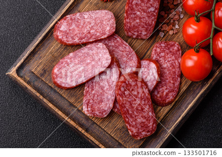 Sliced salami sausage, smoked meat as a delicacy for the table. Salami sausage Sliced salami sausage, smoked meat as a delicacy for the table. Salami sausage 133501716