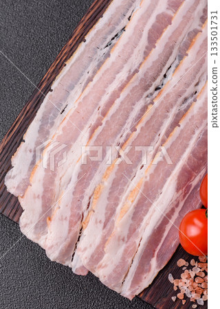 Raw or smoked pork bacon slices or strips as a breakfast ingredient. Raw bacon 133501731
