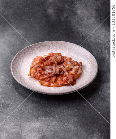 Fried pork bacon slices or strips as a breakfast ingredient. Fried bacon Fried pork bacon slices or strips as a breakfast ingredient. Fried bacon 133501759