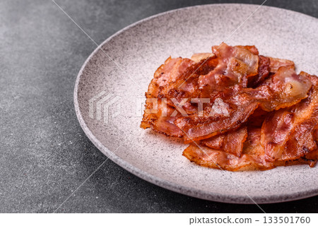 Fried pork bacon slices or strips as a breakfast ingredient. Fried bacon Fried pork bacon slices or strips as a breakfast ingredient. Fried bacon 133501760