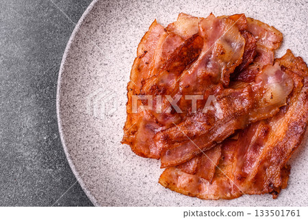 Fried pork bacon slices or strips as a breakfast ingredient. Fried bacon Fried pork bacon slices or strips as a breakfast ingredient. Fried bacon 133501761
