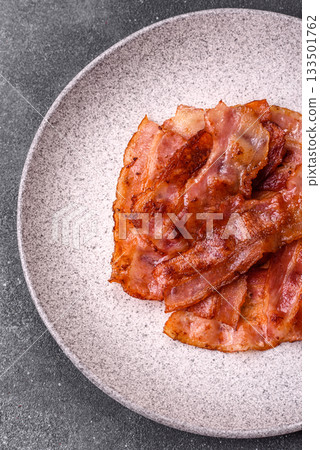 Fried pork bacon slices or strips as a breakfast ingredient. Fried bacon Fried pork bacon slices or strips as a breakfast ingredient. Fried bacon 133501762