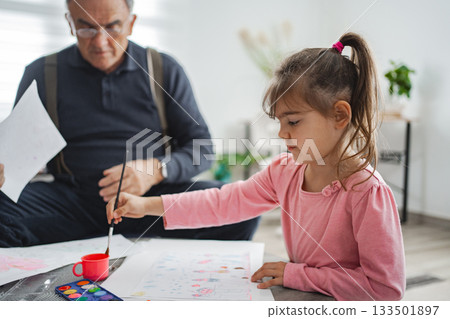 Grandpa and granddaughter painting at home 133501897