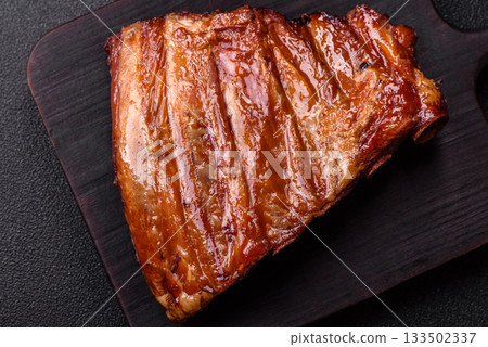 Grilled or barbecued pork or beef ribs with sauce. Cooked or smoked ribs 133502337