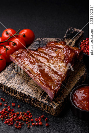 Grilled or barbecued pork or beef ribs with sauce. Cooked or smoked ribs 133502354
