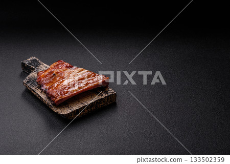 Grilled or barbecued pork or beef ribs with sauce. Cooked or smoked ribs 133502359