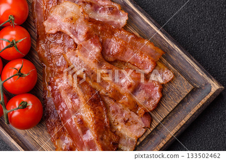 Fried pork bacon slices or strips as a breakfast ingredient. Fried bacon Fried pork bacon slices or strips as a breakfast ingredient. Fried bacon 133502462