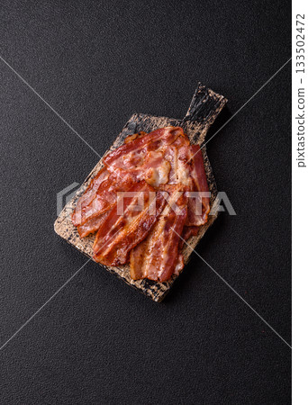 Fried pork bacon slices or strips as a breakfast ingredient. Fried bacon Fried pork bacon slices or strips as a breakfast ingredient. Fried bacon 133502472