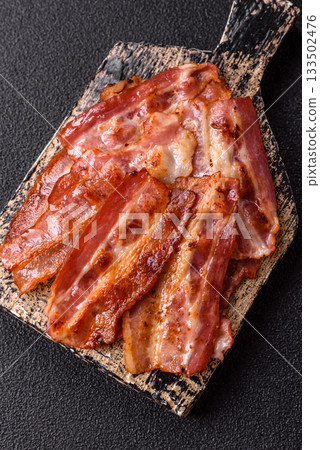 Fried pork bacon slices or strips as a breakfast ingredient. Fried bacon Fried pork bacon slices or strips as a breakfast ingredient. Fried bacon 133502476