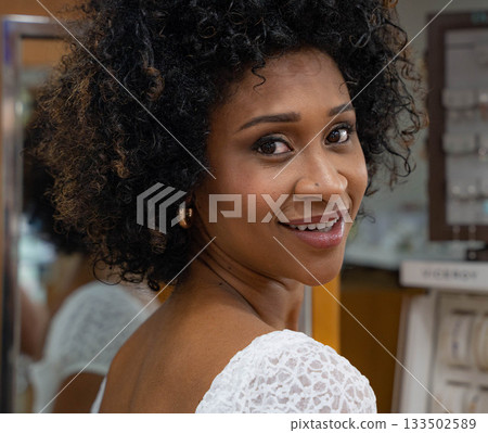 Woman smiles over shoulder Woman smiles over shoulder 133502589