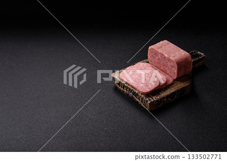 Spiced ham slices, canned meat for lunch sandwiches. Spiced ham as a food background 133502771
