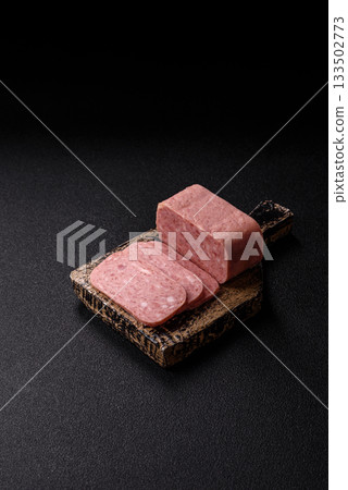 Spiced ham slices, canned meat for lunch sandwiches. Spiced ham as a food background 133502773