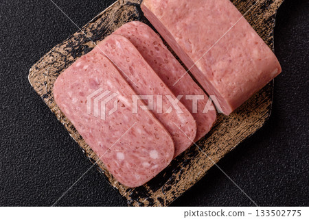 Spiced ham slices, canned meat for lunch sandwiches. Spiced ham as a food background 133502775