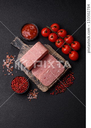 Spiced ham slices, canned meat for lunch sandwiches. Spiced ham as a food background Spiced ham slices, canned meat for lunch sandwiches. Spiced ham as a food background 133502784