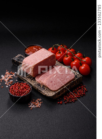 Spiced ham slices, canned meat for lunch sandwiches. Spiced ham as a food background 133502785