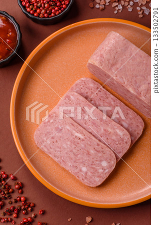 Spiced ham slices, canned meat for lunch sandwiches. Spiced ham as a food background Spiced ham slices, canned meat for lunch sandwiches. Spiced ham as a food background 133502791