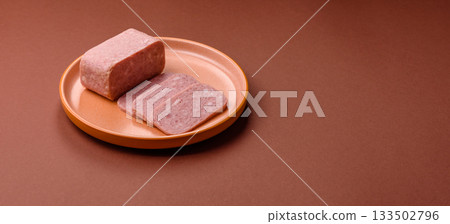 Spiced ham slices, canned meat for lunch sandwiches. Spiced ham as a food background 133502796