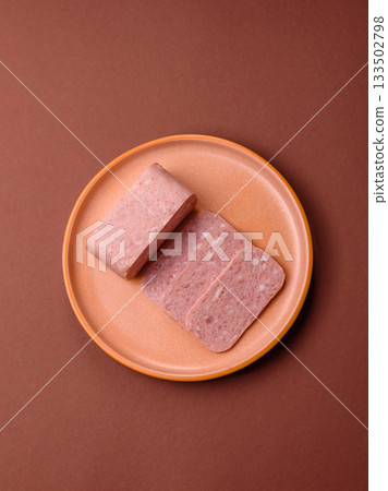 Spiced ham slices, canned meat for lunch sandwiches. Spiced ham as a food background 133502798