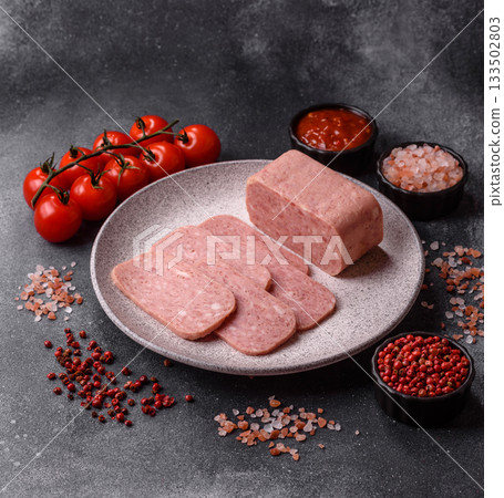 Spiced ham slices, canned meat for lunch sandwiches. Spiced ham as a food background 133502803