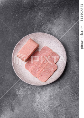 Spiced ham slices, canned meat for lunch sandwiches. Spiced ham as a food background 133502813