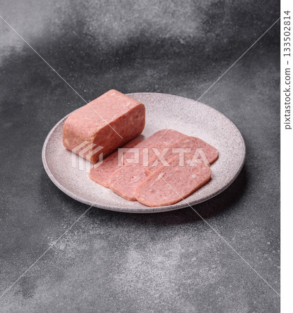 Spiced ham slices, canned meat for lunch sandwiches. Spiced ham as a food background 133502814