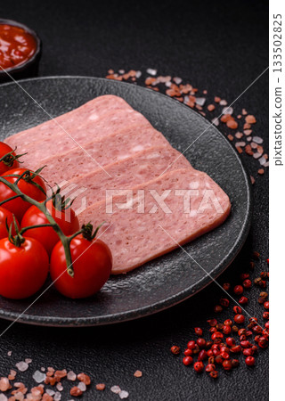 Spiced ham slices, canned meat for lunch sandwiches. Spiced ham as a food background Spiced ham slices, canned meat for lunch sandwiches. Spiced ham as a food background 133502825