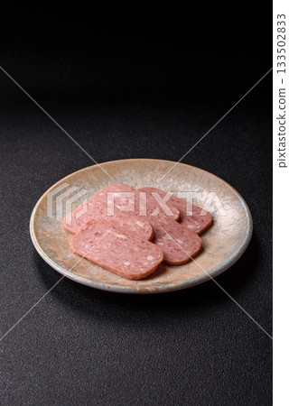 Spiced ham slices, canned meat for lunch sandwiches. Spiced ham as a food background 133502833